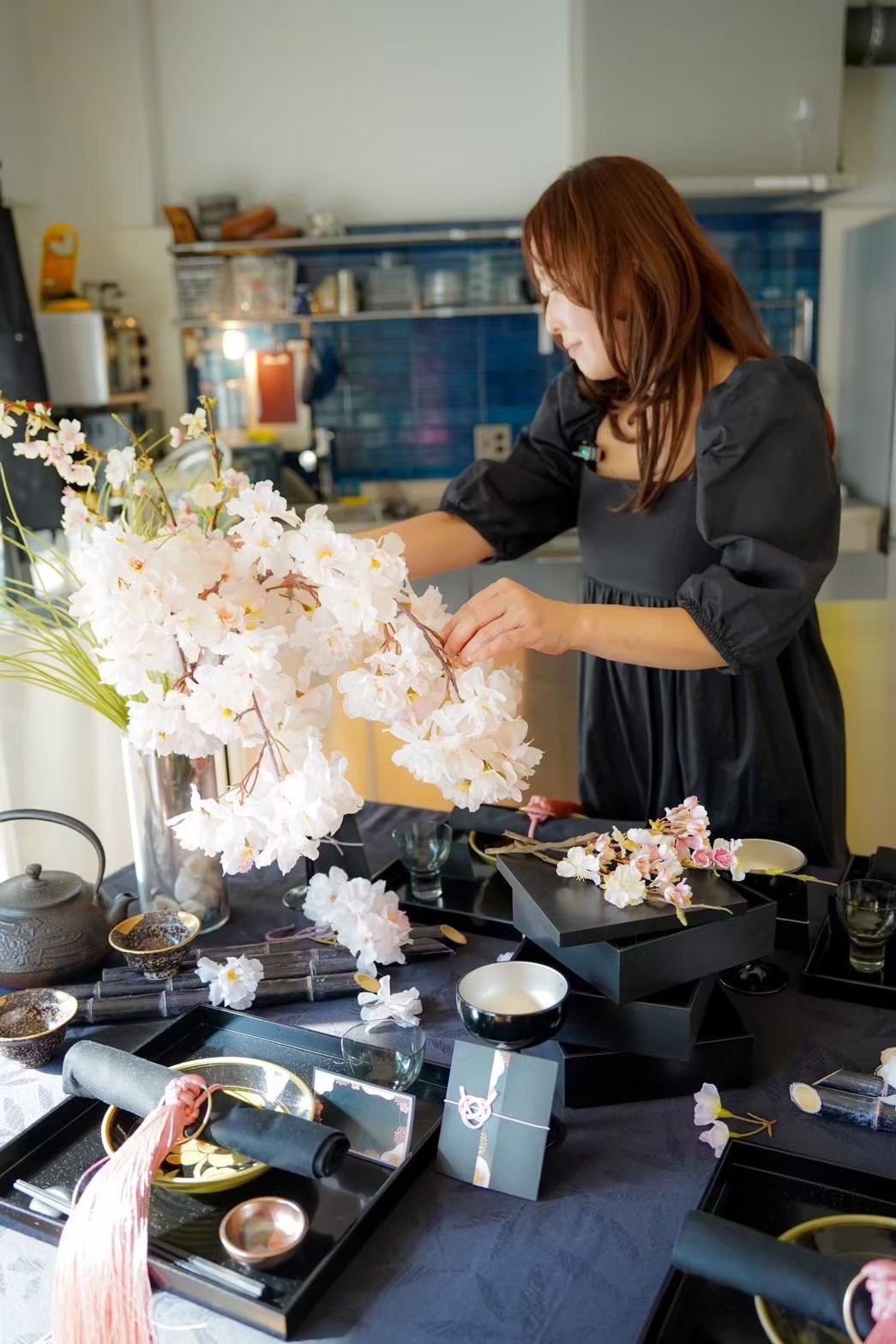 桜の枝を活けながら、テーブルを整える講師